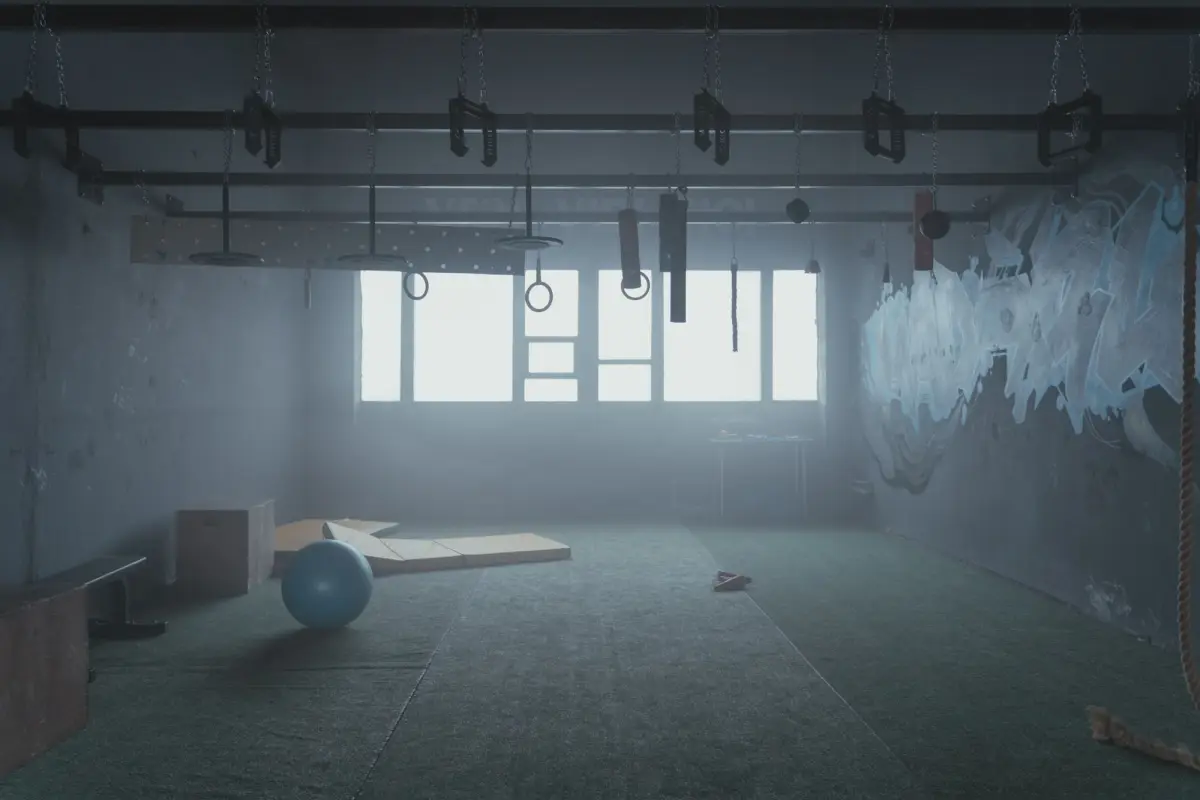 Sala de entrenamiento con anillas colgadas, cajas de salto y colchonetas
